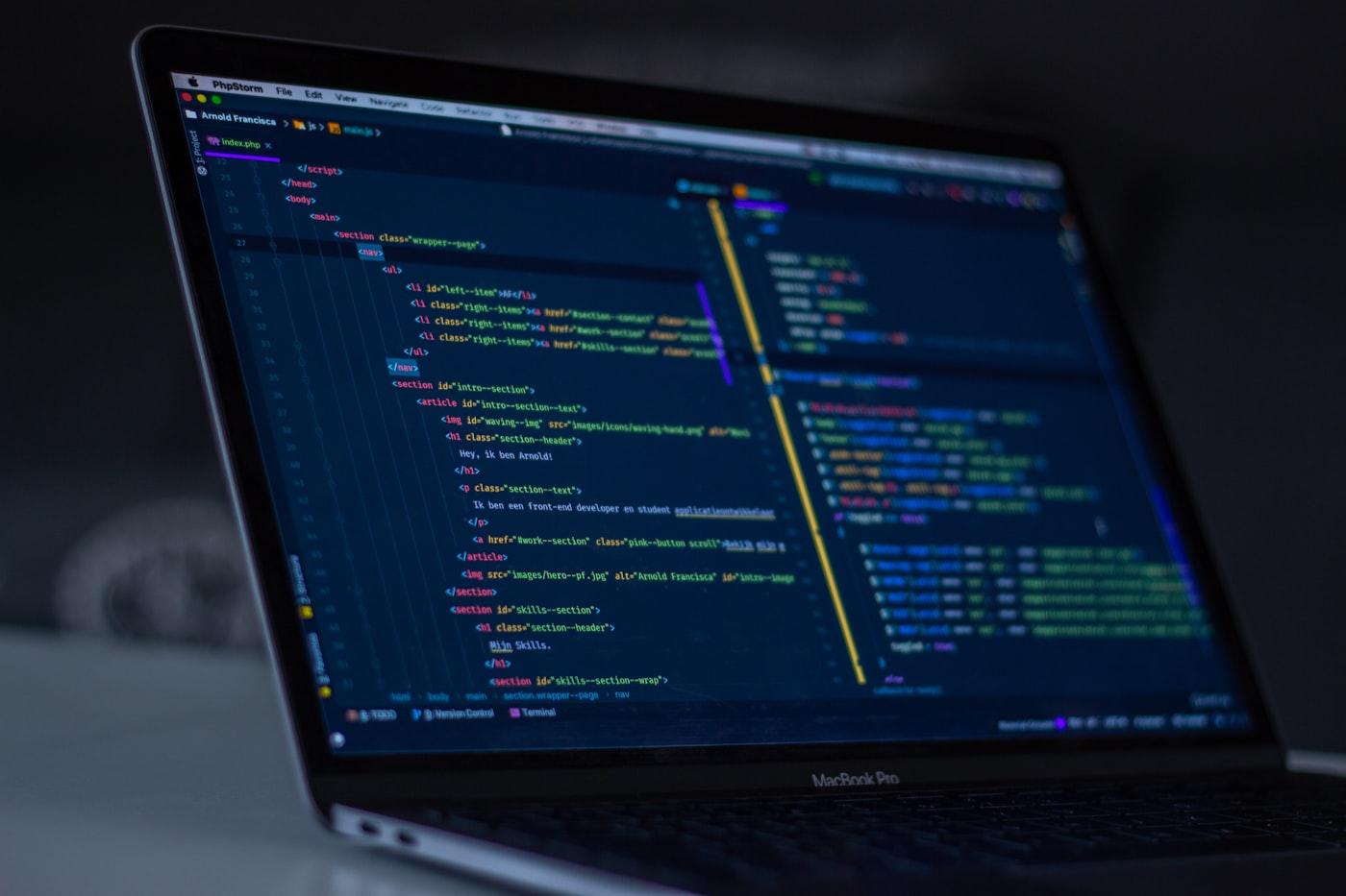 Dark-mode IDE with custom scripts open on a laptop